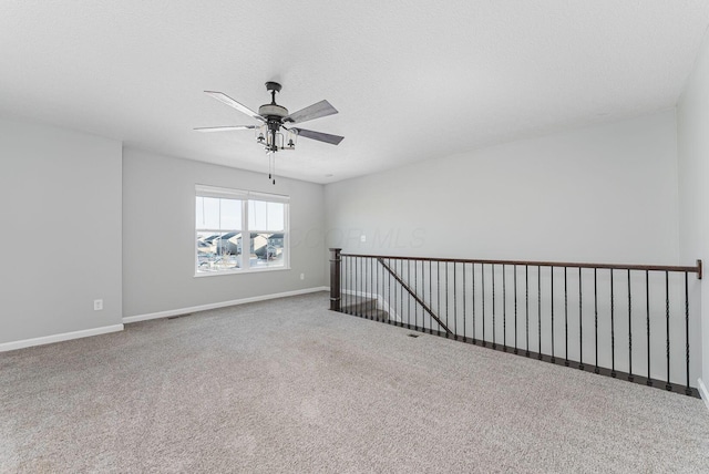 unfurnished room with ceiling fan, carpet floors, and a textured ceiling