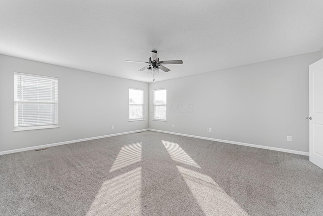 carpeted spare room with ceiling fan