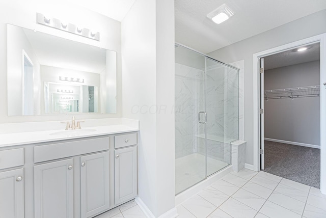 bathroom featuring vanity, a textured ceiling, and walk in shower