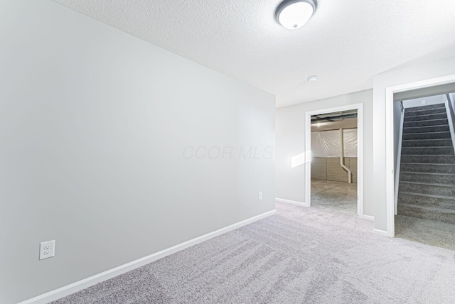 spare room with carpet flooring and a textured ceiling