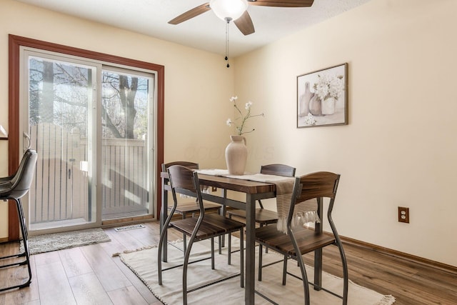 dining area with light hardwood / wood-style flooring and ceiling fan