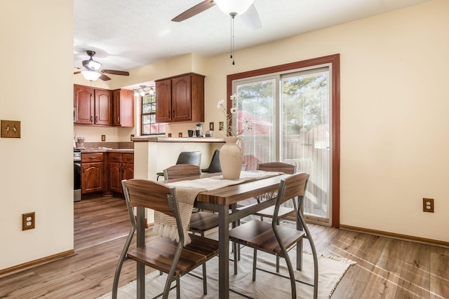 dining space with a textured ceiling, ceiling fan, and light hardwood / wood-style flooring