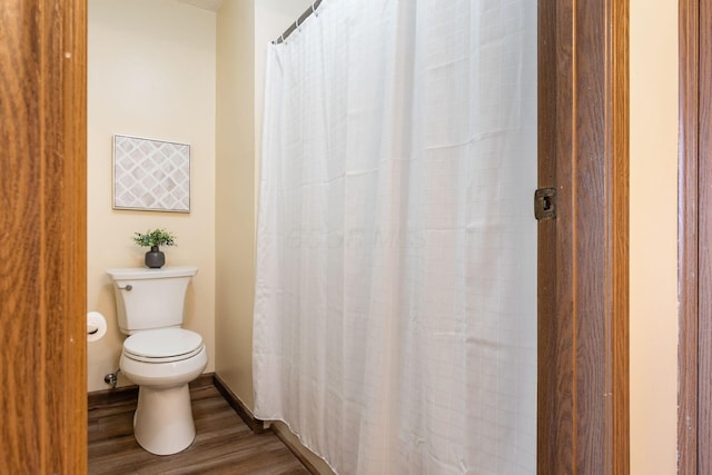 bathroom with hardwood / wood-style floors and toilet