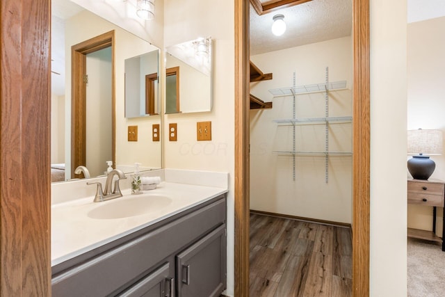 bathroom with vanity, hardwood / wood-style floors, and a textured ceiling