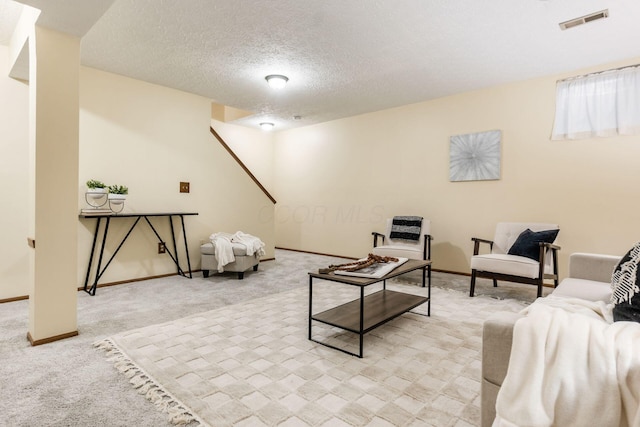 carpeted living room featuring a textured ceiling