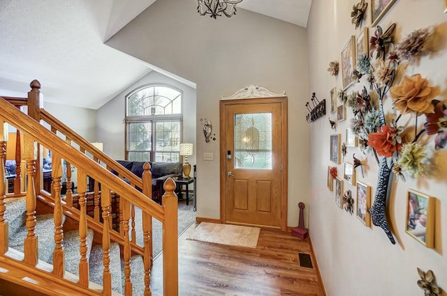 entrance foyer with lofted ceiling and hardwood / wood-style floors