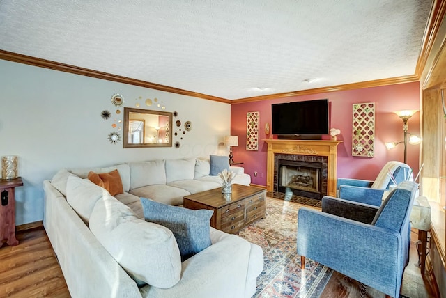 living room with hardwood / wood-style flooring, ornamental molding, a textured ceiling, and a fireplace