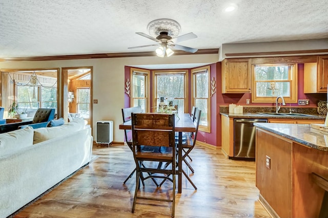 kitchen featuring dishwasher, sink, dark stone countertops, light hardwood / wood-style floors, and a textured ceiling