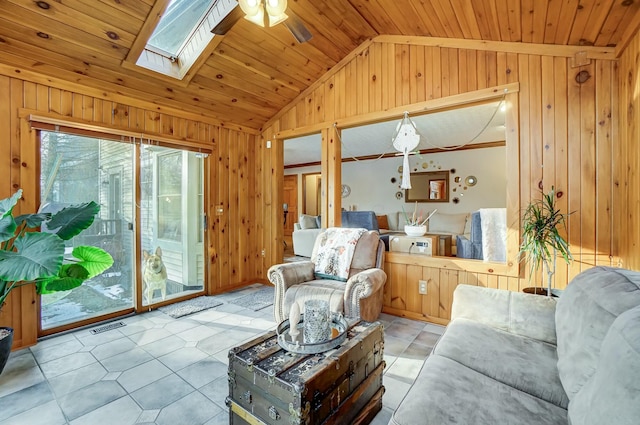 living room featuring wood ceiling, wooden walls, lofted ceiling with skylight, and ceiling fan