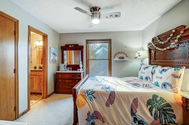 carpeted bedroom featuring ensuite bath, a textured ceiling, and ceiling fan