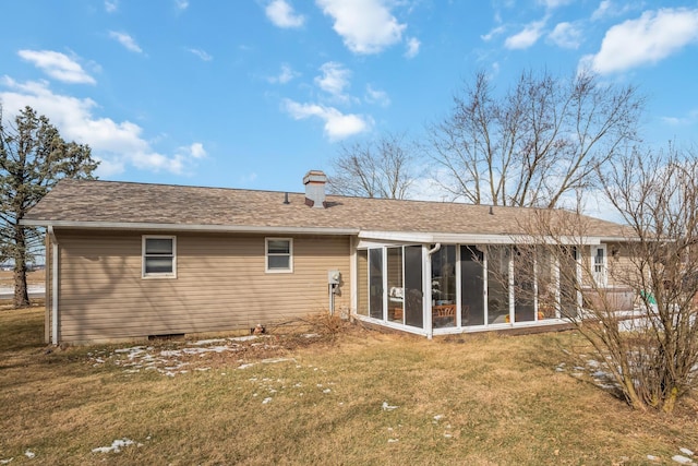 rear view of house featuring a lawn and a sunroom