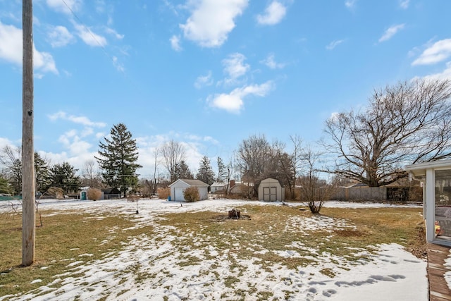 snowy yard featuring a storage unit