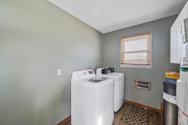 laundry room featuring washer and dryer, heating unit, and dark wood-type flooring