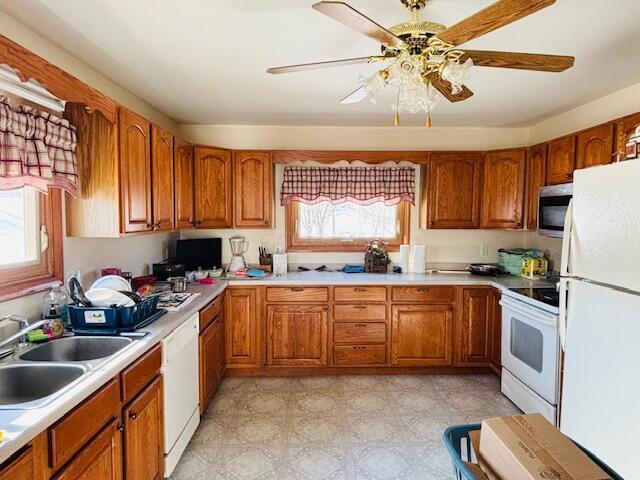 kitchen with sink, white appliances, and ceiling fan