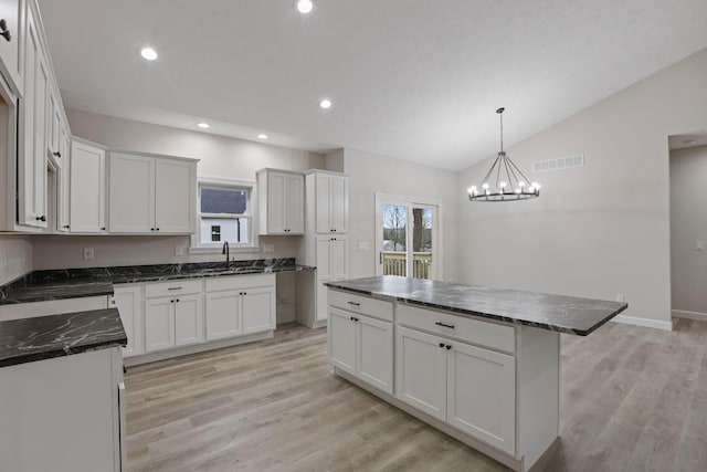 kitchen featuring white cabinetry, sink, and a kitchen island