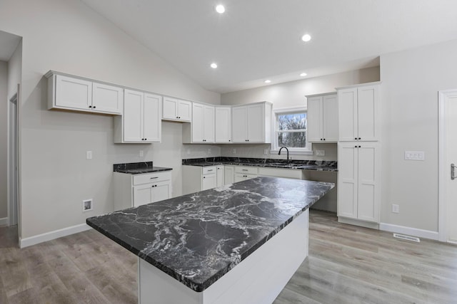 kitchen featuring white cabinetry, a center island, sink, and light hardwood / wood-style floors