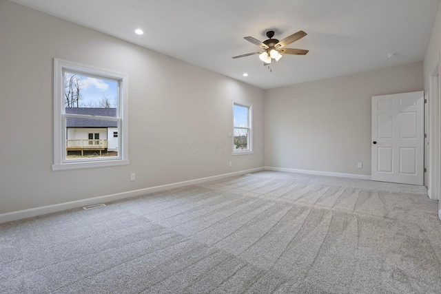 spare room featuring light colored carpet and ceiling fan