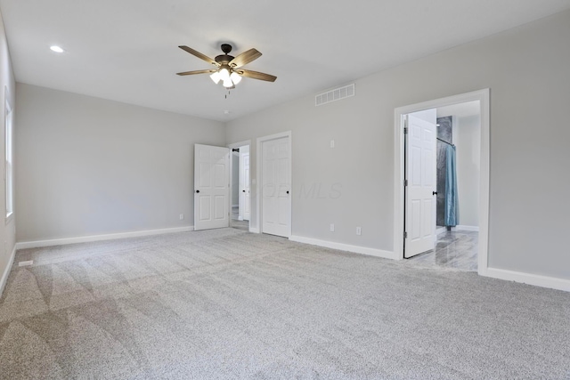 spare room with ceiling fan and light colored carpet