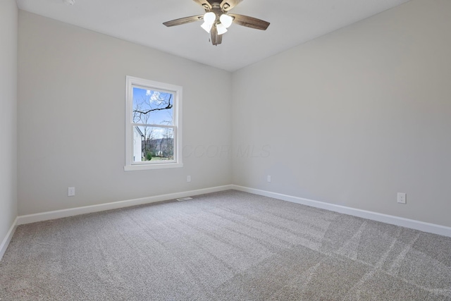 empty room featuring ceiling fan and carpet