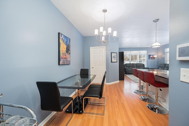 dining room with an inviting chandelier, hardwood / wood-style floors, and a textured ceiling