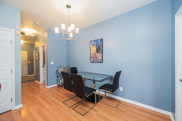 dining room featuring a notable chandelier and light wood-type flooring