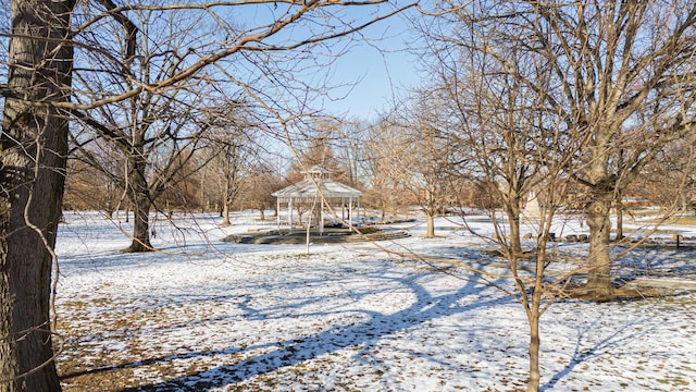 yard layered in snow with a gazebo