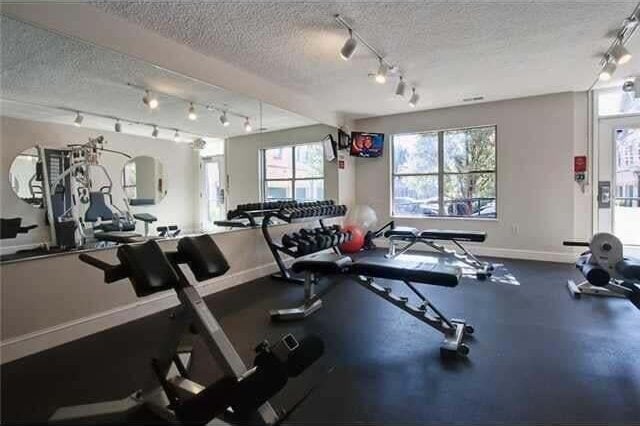 exercise room featuring a textured ceiling and a wealth of natural light