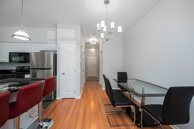 674 Park St, Columbus, OH 43215 - dining area featuring light wood-type flooring and a chandelier