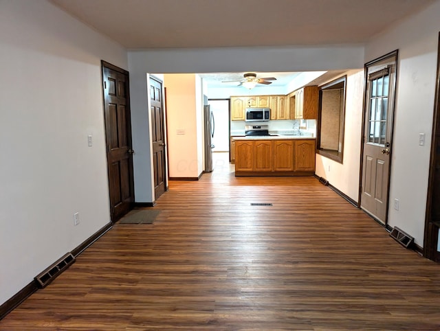 kitchen featuring dark wood-style floors, appliances with stainless steel finishes, a sink, and visible vents