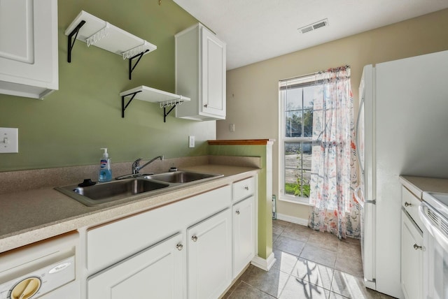 kitchen featuring a healthy amount of sunlight, sink, white cabinets, and light tile patterned flooring