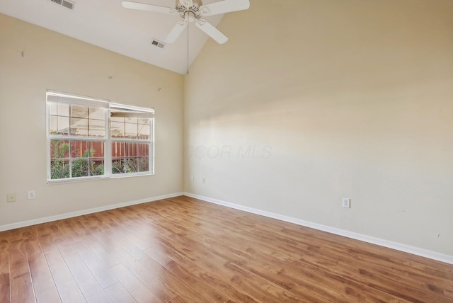 spare room with hardwood / wood-style flooring, ceiling fan, and high vaulted ceiling