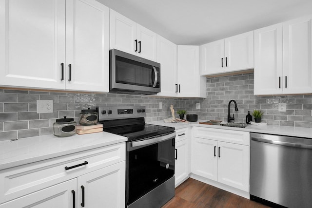 kitchen featuring tasteful backsplash, stainless steel appliances, and white cabinets