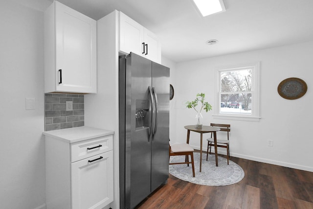 kitchen with tasteful backsplash, dark hardwood / wood-style floors, stainless steel fridge with ice dispenser, and white cabinets