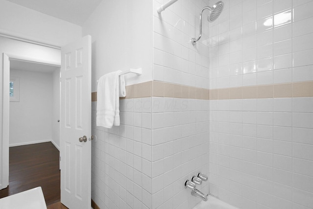 bathroom featuring tiled shower / bath combo and hardwood / wood-style floors