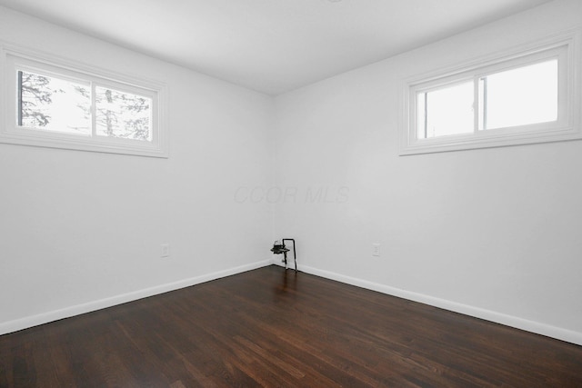 unfurnished room with a healthy amount of sunlight and dark hardwood / wood-style floors