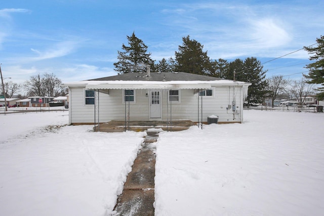 view of snow covered rear of property