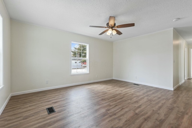 unfurnished room featuring dark wood-style floors, baseboards, visible vents, and a textured ceiling