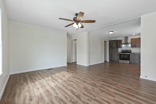 unfurnished living room featuring visible vents, a ceiling fan, a textured ceiling, wood finished floors, and baseboards