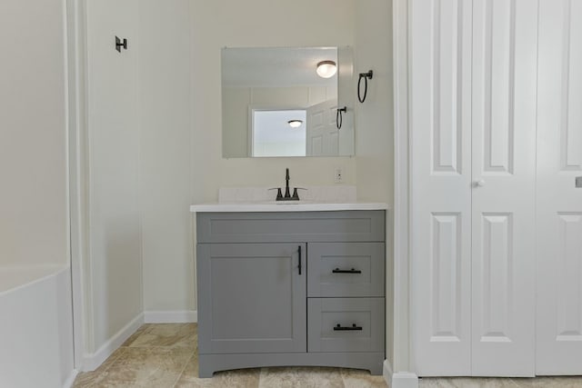 full bathroom featuring baseboards, a closet, and vanity