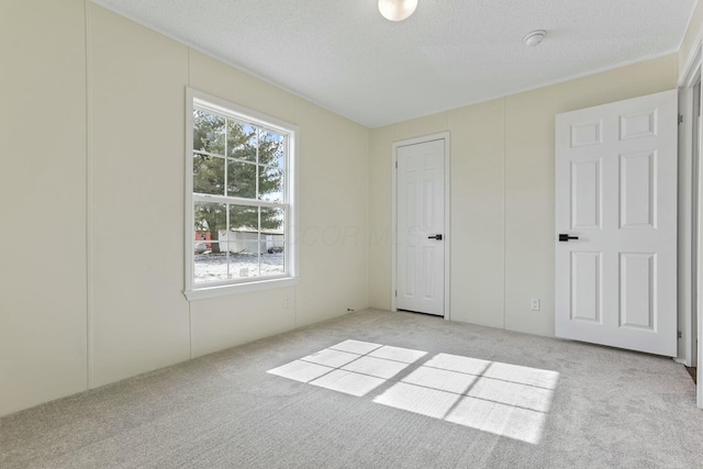 unfurnished bedroom featuring light carpet and a textured ceiling