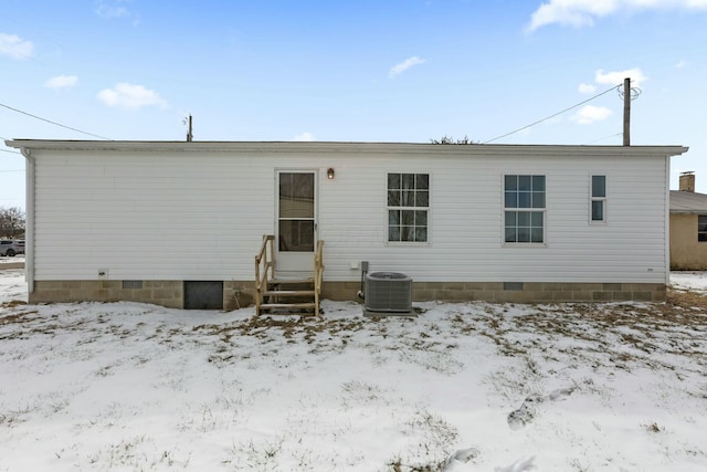 snow covered house with entry steps, crawl space, and central air condition unit