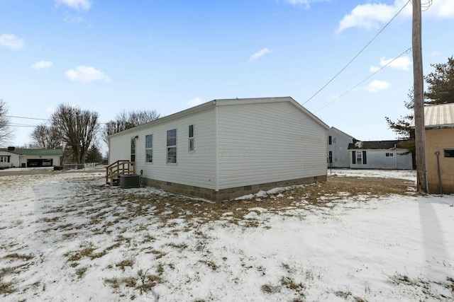 view of snowy exterior with crawl space and central air condition unit