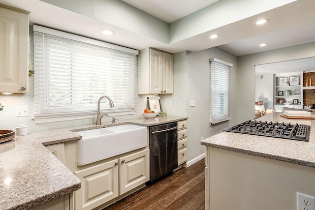 kitchen featuring appliances with stainless steel finishes, dark hardwood / wood-style floors, cream cabinets, sink, and light stone countertops