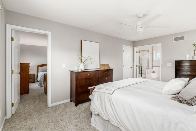 bedroom featuring ensuite bathroom, light carpet, and ceiling fan