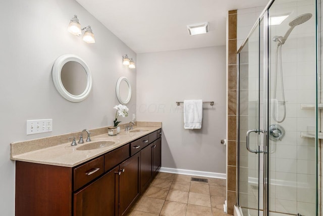 bathroom with an enclosed shower, vanity, and tile patterned flooring