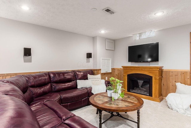 carpeted living room featuring a textured ceiling and wood walls