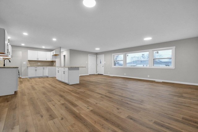 unfurnished living room featuring sink and light wood-type flooring