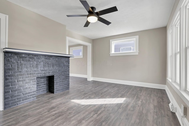 unfurnished living room with dark wood-type flooring, ceiling fan, and a fireplace