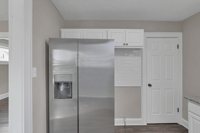 kitchen featuring stainless steel fridge, dark hardwood / wood-style flooring, light stone countertops, and white cabinets