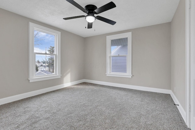 carpeted empty room featuring ceiling fan and a textured ceiling